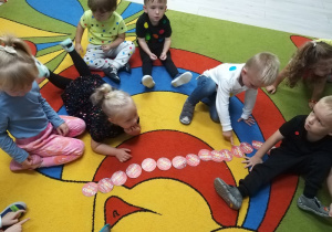 Dzieci układają kropki obok siebie zgodnie z instrukcją.