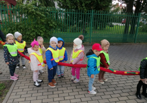 Grupka dzieci obserwuje ruch drogowy.