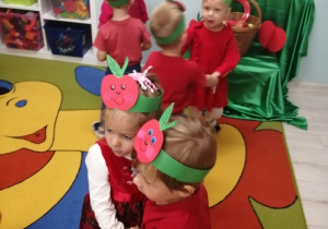 Dzieci podczas zabawy przy piosence "Małe czerwone jabłuszko" ustawione w małe kółeczka.