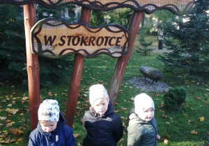 Dzieci pozują do zdjęcia obok witacza z napisem Ścieżka ekologiczno - przyrodnicza w „ Stokrotce ".