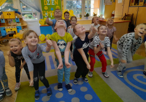 Dzieci z radością poruszają się przy piosence „Chu chu ua” na dywanie.