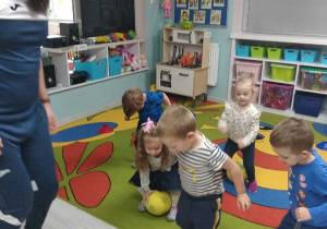 Grupka dzieci wykonuje skoki z piłką.