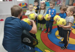 Wszystkie dzieci ustawione w rzędzie z piłkami.