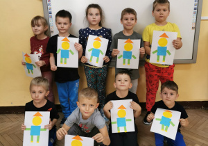 Dzieci z grypy "Słoneczka" prezentują swoje prace plastyczne - pajacyki wykonane z figur geometrycznych.