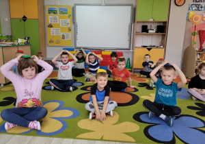Biedronki w trakcie zabawy z woreczkami- dzieci trzymają woreczki na głowie.