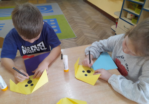Mieszko i Alicja rysują flamastrem pyszczek swojemu pieskowi.