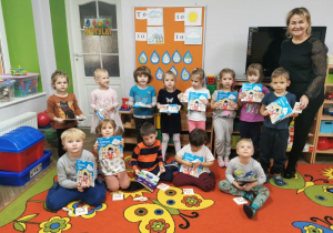 Dzieci z grupy "Motylki" prezentują otrzymane upominki - kolorowanki, kredki i balony.