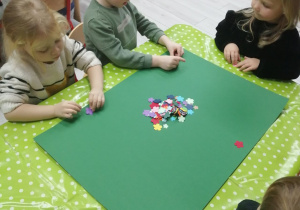Grupka dzieci podczas pracy plastycznej „Dywan dla Świętego Mikołaja”.