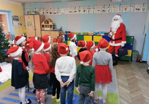 Przedszkolaki witają Świętego Mikołaja, który wszedł do sali.
