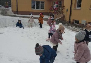 Maluchy sprawdzają jaki jest śnieg, czy lepi się i czy można zrobić bałwana.