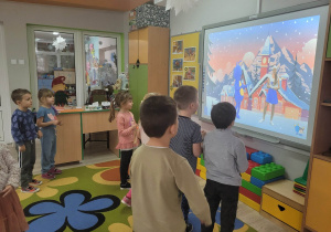 Dzieci z grupy Biedronek w trakcie zabawy przy tablicy multimedialnej.