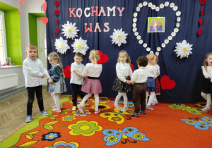 Dzieci podczas zabawy tanecznej „Nie chcę…”. Z tyłu dekoracja z sercami i napisem.