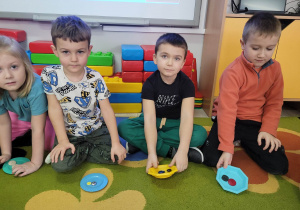 Anastazja, Eryk, Gabryś i Franio z grupy Biedronek w trakcie zabawy z przeliczaniem guzików.