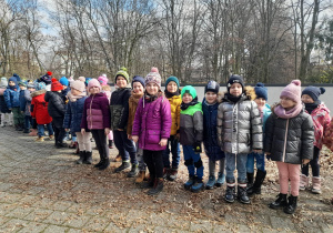 Dzieci z grupy IV "Słoneczka" i III "Biedronki" stoją na chodniku po wyjściu z KDK.