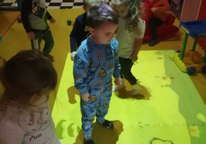 Grupka dzieci podczas zabawy "Poszukiwanie pingwinka" na dywanie kreatywnym.