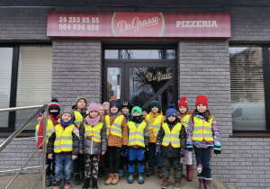 Grupa "Słoneczka" stoi przed wejściem do pizzerii "Da Grasso".