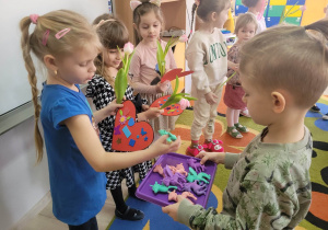 Samuelek wręcza dziewczynkom gumki w kształcie kolorowych jednorożców.