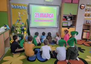 "Biedronki' siedzą na dywanie i oglądają film edukacyjny o wiośnie.