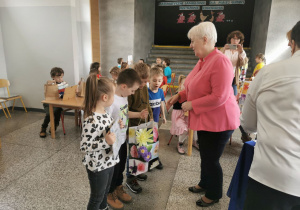"Słoneczka" odbierają nagrodę i gratulację za wyróżnienie od pani dyrektor .