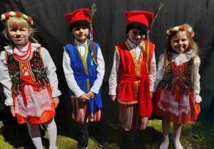 Alicja, Hubert, Igor i Gabrysia ubrani w stroje krakowskie stoją obok sceny w parku Traugutta.