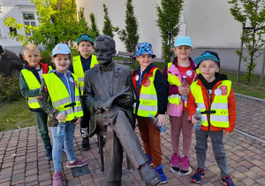 Dzieci pozują do zdjęcia przy pomniku Doktora Antoniego Troczewskiego na placu przed siedzibą Urzędu Stanu Cywilnego.