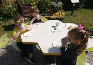 Grupka dzieci pije nektar pszczeli.