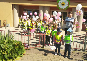 Maluchy i Motylki przygotowane do spaceru z radością prezentują stokrotki i urodzinowe balony.