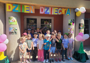 Dzieci z grupy Biedronek wspólnie pozują do zdjęcia na przedszkolnym tarasie