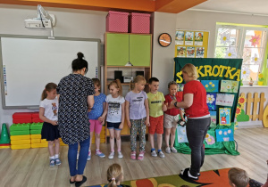 Pani Lidka i pani Małgosia wręczają nagrody w postaci kart podarunkowych dzieciom z grupy "Słoneczka".