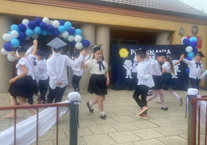 Dzieci z grupy "Słoneczka" tańczą taniec narodowy "Polonez" na tarasie przedszkolnym.