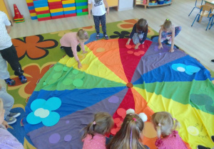 Dzieci z grupy "Biedronek" segregują kropki według koloru i układają na chuście animacyjnej.