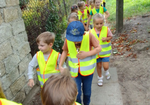 "Biedronki" w kamizelkach odblaskowych idą do pobliskiego sklepu.