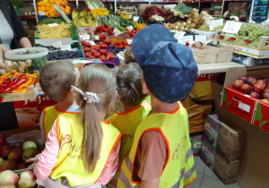 Grupa "Biedronek" ogląda półki wypełnione różnymi owocami i warzywami.
