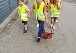 "Biedronki" z koszem śliwek wracają do przedszkola.