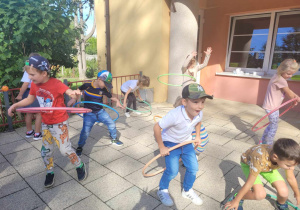 Dzieci z grupy "Słoneczek" w trakcie zabaw z kołami Hula Hop.