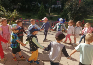Dzieci ustawione w kole na tarasie przedszkolnym.