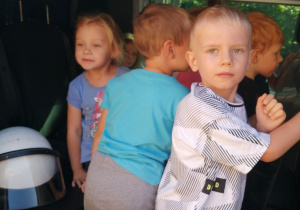 Grupka dzieci ogląda policyjny radiowóz.