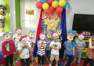 Zdjęcie grupowe chłopców w otrzymanych maskach na tle dekoracji.