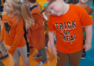 Dzieci tańczą przy muzyce poruszając głowami.