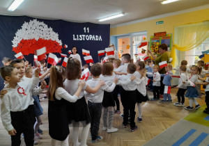 Dzieci ze wszystkich grup jadą w pociągach do piosenki "Jestem Polakiem". W rękach trzymają papierowe biało-czerwone flagi.