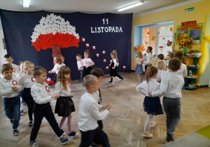 Dzieci w parach idą po obwodzie koła przy piosence "Jesienny Kujawiaczek".