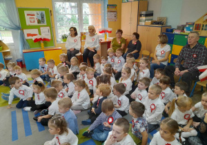 Dzieci wraz z pracownikami przedszkola oglądają przedstawienie z okazji Święta Niepodległości.