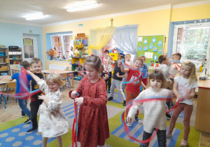 Dzieci wykonują "Taniec wiatru" przy muzyce poruszając paskami bibuły.