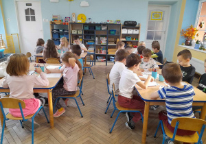Dzieci siedzą przy stolikach i wykonują kartę z Dzienniczka Małego Misia - rysują obrazek Misia.