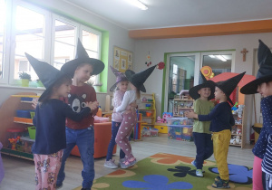 Dzieci tańczą na dywanie w parach podczas zabawy „Taniec przyklejaniec”.