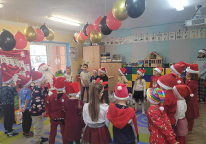 Mikołaj siedzi na „tronie”, wokół przedszkolaki ustawione w półkole śpiewają przygotowaną specjalnie dla niego piosenkę
