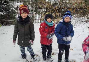 Julek, Tomek i Kacper lepią śniegowe kulki przygotowują się do bitwy na śnieżki