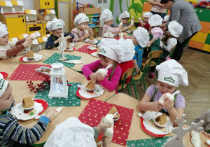 Dzieci wyciskają biały lukier na muffinkę.