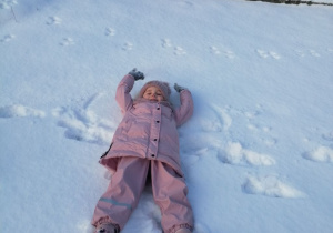 Marysia robi "aniołka" na śniegu.