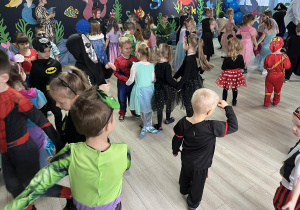 Przedszkolaki ze wszystkich grup tańczą na sali balowej.